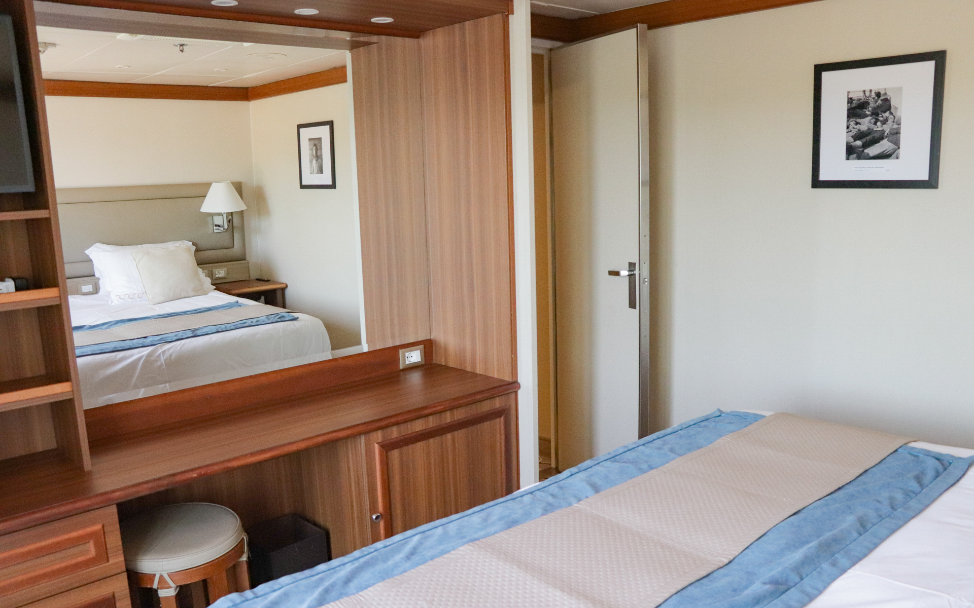 Owner's Suite aboard Discoverer: Polar Latitudes with large mirror, stool, storage and large bed with white linens.