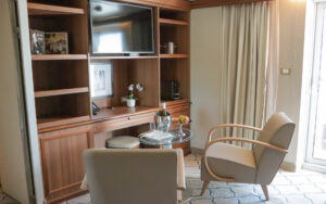 Living room area with two arm chairs, small table and television in Owner's Suite on small ship Discoverer: Polar Latitudes