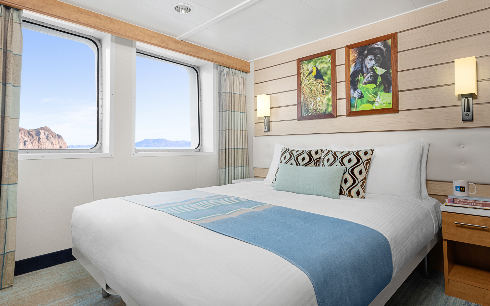 Cat 3 cabin aboard National Geographic Venture expedition ship with queen that can convert to 2 single beds, 2 windows & nightstand.
