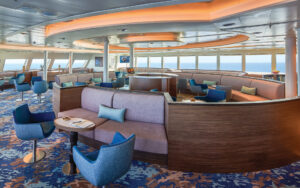 Round seating structure with several couches, tables, and armchairs spread throughout lounge aboard National Geographic Venture