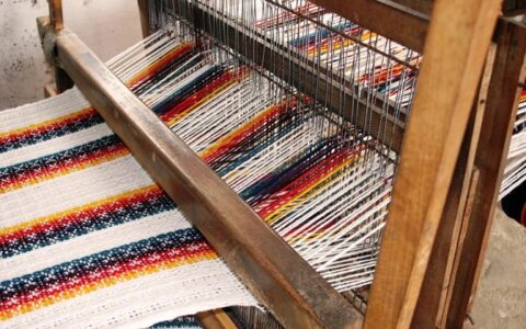 large tapestry being woven on loom on otavalo escape ecuador land tour