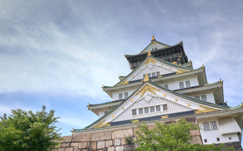 Osaka Castle with multiple floors, ornate rooflines & exterior in white, teal & gold, seen on a Sacred Japan & South Korea cruise.