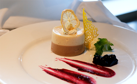 beautiful lemon tart with blackberries dessert aboard Magellan explorer on a white plate