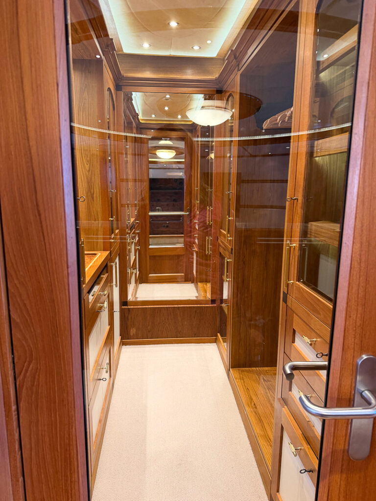 his-and-hers walk-in closets inside owner suite aboard Aqua Lares, rich wood and glass appointments. 